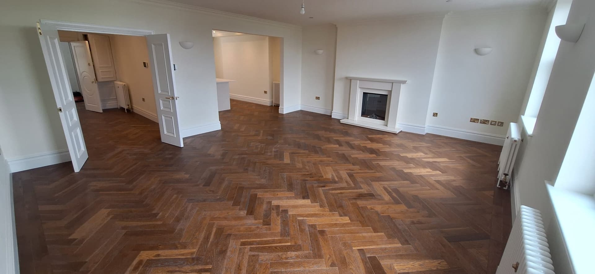 A restored reception room with herringbone parquet flooring